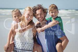 Portrait of happy family piggybacking at beach