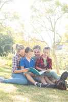 Family reading a book in the park