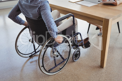 Handicapped executive sitting on wheelchair at desk