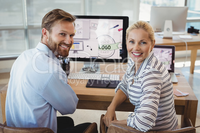 Portrait of executives sitting at desk Portrait of executives sitting at desk
