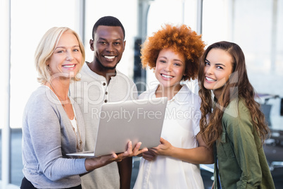 Portrait of happy colleagues with laptop