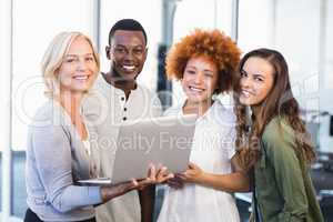 Portrait of happy colleagues with laptop