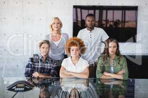 Portrait of confident colleagues at desk