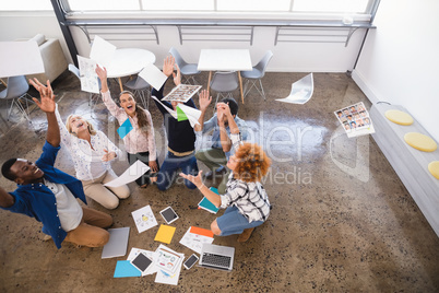 Cheerful business team tossing papers at office