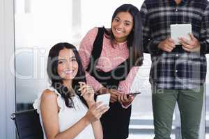 Portrait of smiling business colleagues using mobile phones