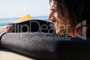 Surfer leaning on surfboard in sea