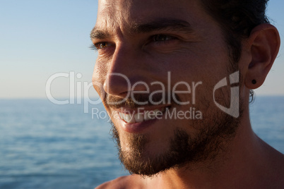 Close up of smiling man looking away at beach