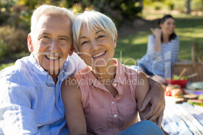 Portrait of happy senior couple sitting in the park