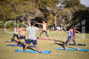 Female trainer teaching children stretching exercise