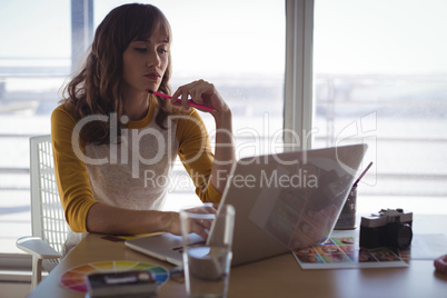 Young businesswoman working on laptop in office