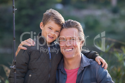 Portrait of happy father and son with fishing rod