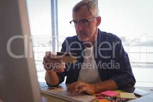Serious businessman shopping online with credit card at office
