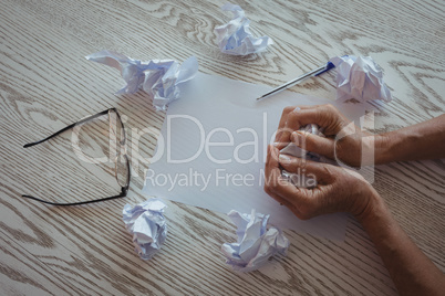 Hands of businesswoman crumpling papers on desk in office