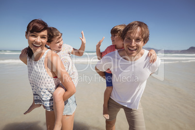 Portrait of happy parents piggybacking their children