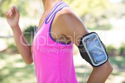 Female jogger with arm band jogging in the park