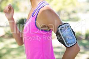 Female jogger with arm band jogging in the park