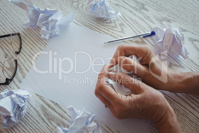 Businesswoman crumpling papers on desk in office