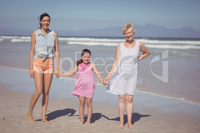 Portrait of happy multi-generation family holding hands at beach