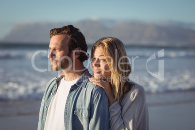 Young couple looking away at beach