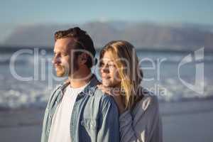 Young couple looking away at beach
