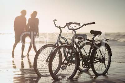 Bicycles parking on shore with couple in background