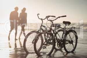 Bicycles parking on shore with couple in background