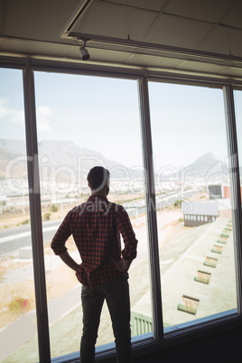 Businessman looking through glass window in office