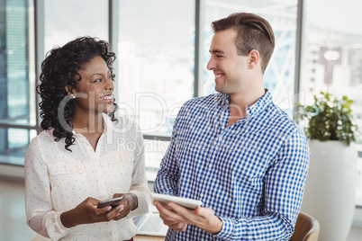 Happy executives using digital tablet and mobile phone