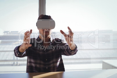 Businessman using virtual reality headset in creative office