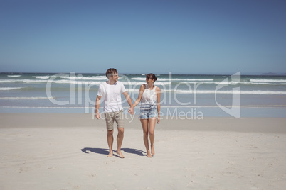 Full length of couple holding hands at beach