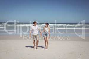 Full length of couple holding hands at beach