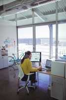 Confident female designer using digitizer on desk in office