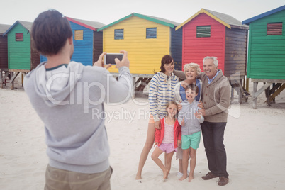 Man photographing family at beach