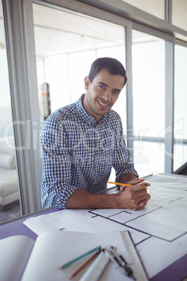 Smiling male interior designer working in office