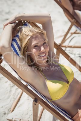 High angle portrait of woman relaxaing on lounge chair at beach