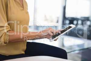 Midsection of businesswoman using tablet