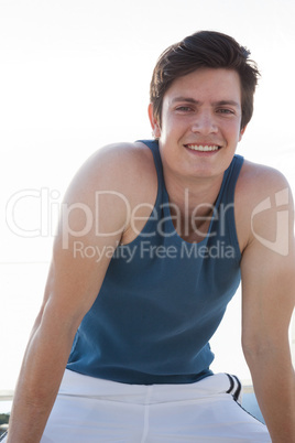 Smiling man taking break after jogging on beach