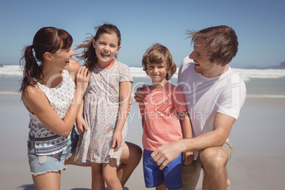 Happy siblings with parents at beach