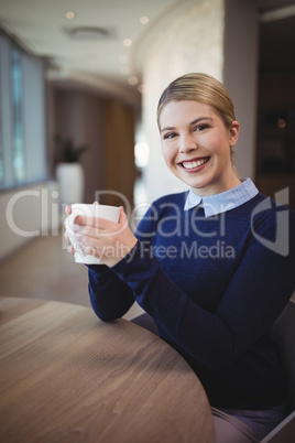 Portrait of smiling executive having coffee