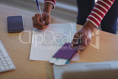 Businesswoman signing documents on desk in office