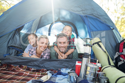 Smiling family lying in the tent