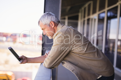 Mature businessman using tablet pc in balcony