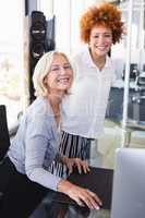 Portrait of smiling businesswomen at desk