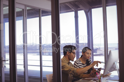 Businessman discussing strategies with female colleague in office