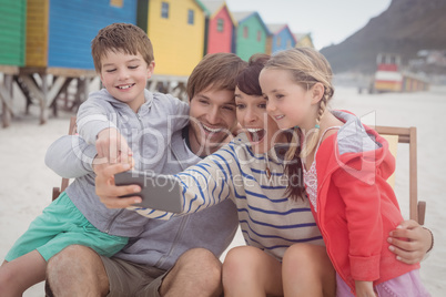 Cheerful family taking selfie at beach