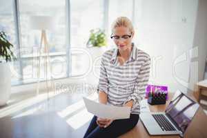 Attentive executive reading document at desk