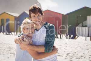 Portrait of happy mother embracing her son at beach