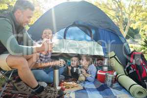 Family interacting while having snacks outside the tent