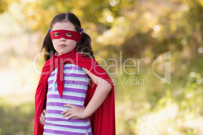 Little girl wearing superhero costume at campsite
