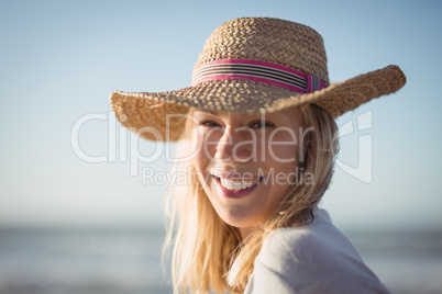 Portrait of happy woman wearing sun hat at beach